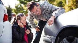 A couple check the damage to their car.